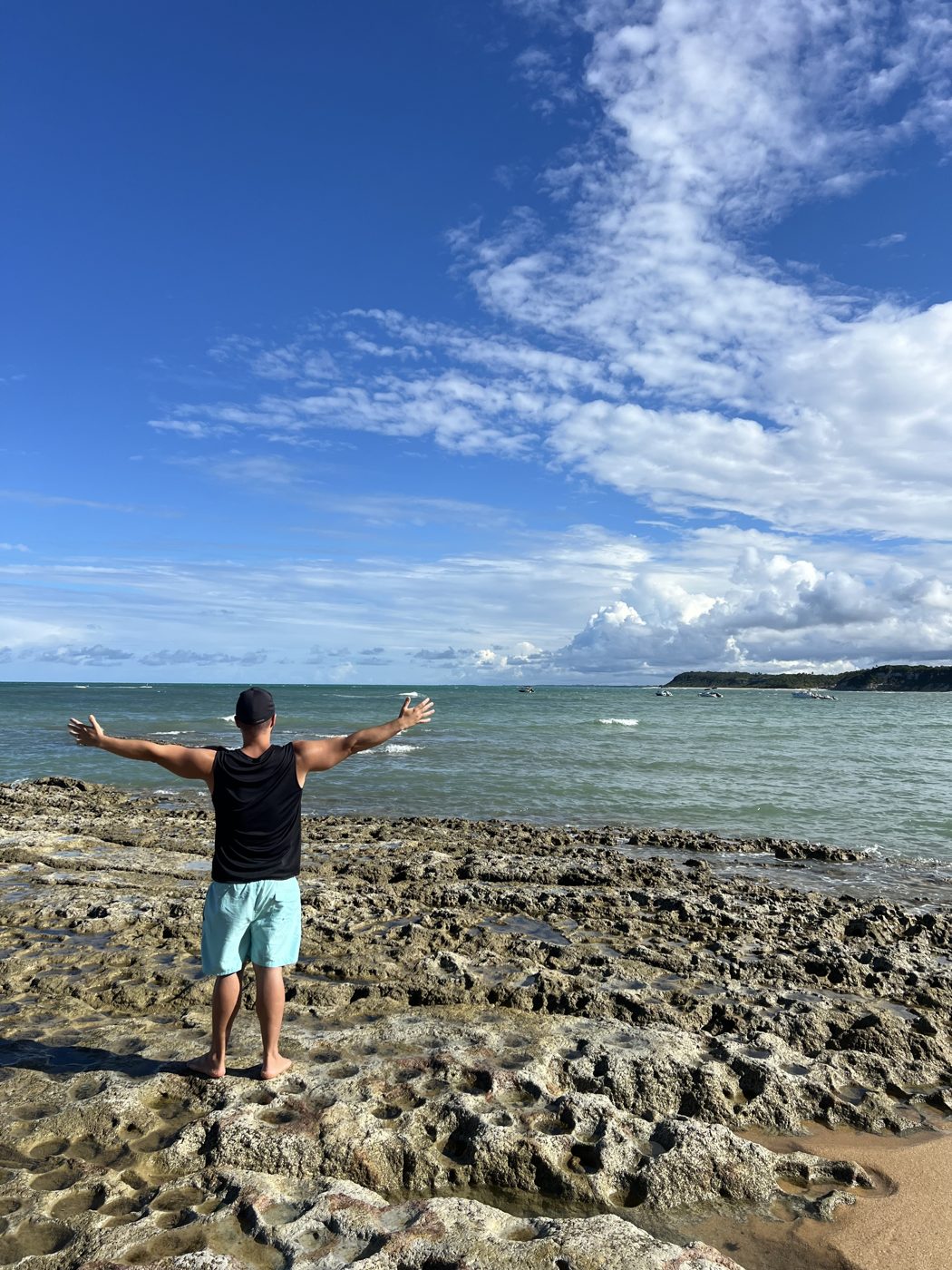 Eu de braços abertos de frente para o mar
